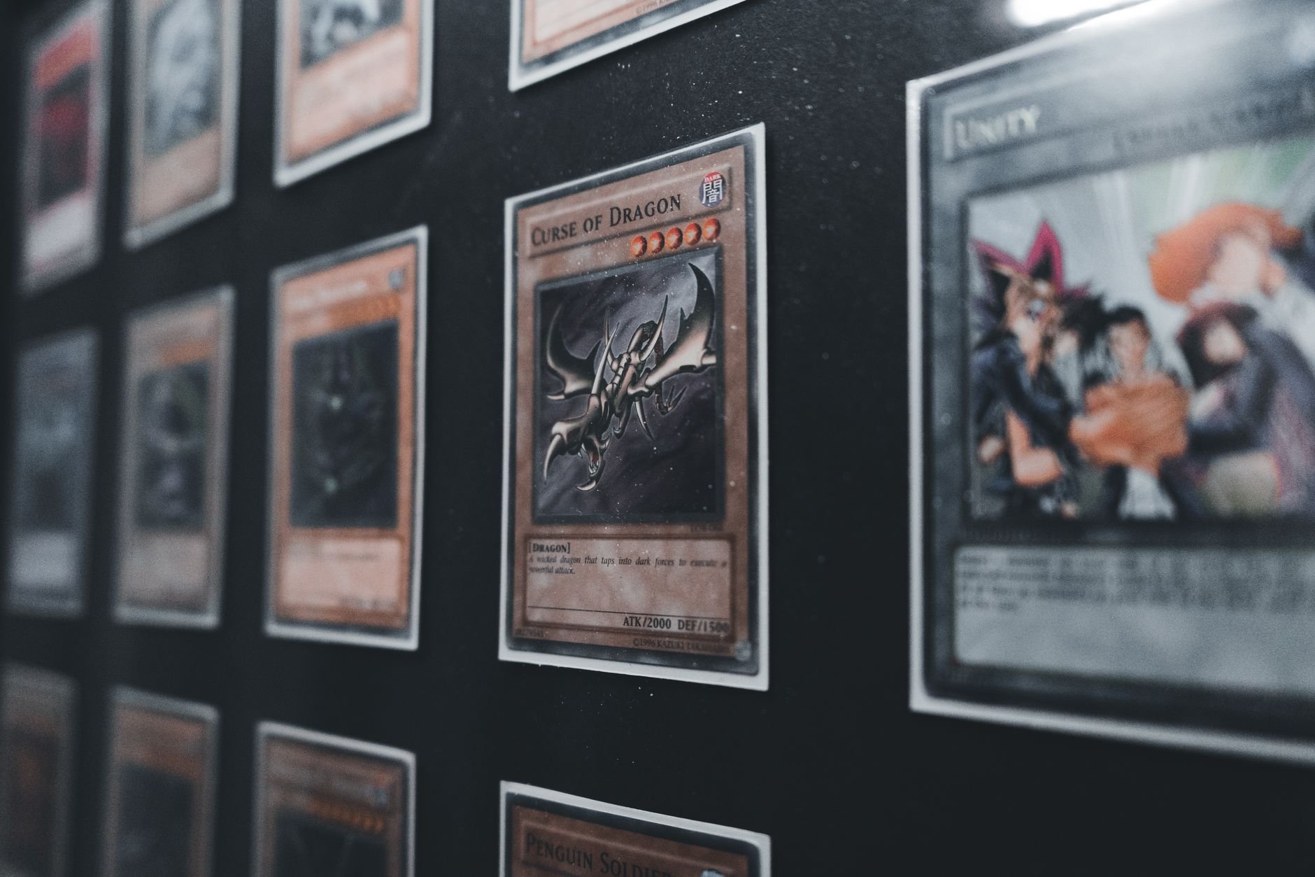 A close-up display of collectible trading cards in a case, showing the detail and condition collectors care about